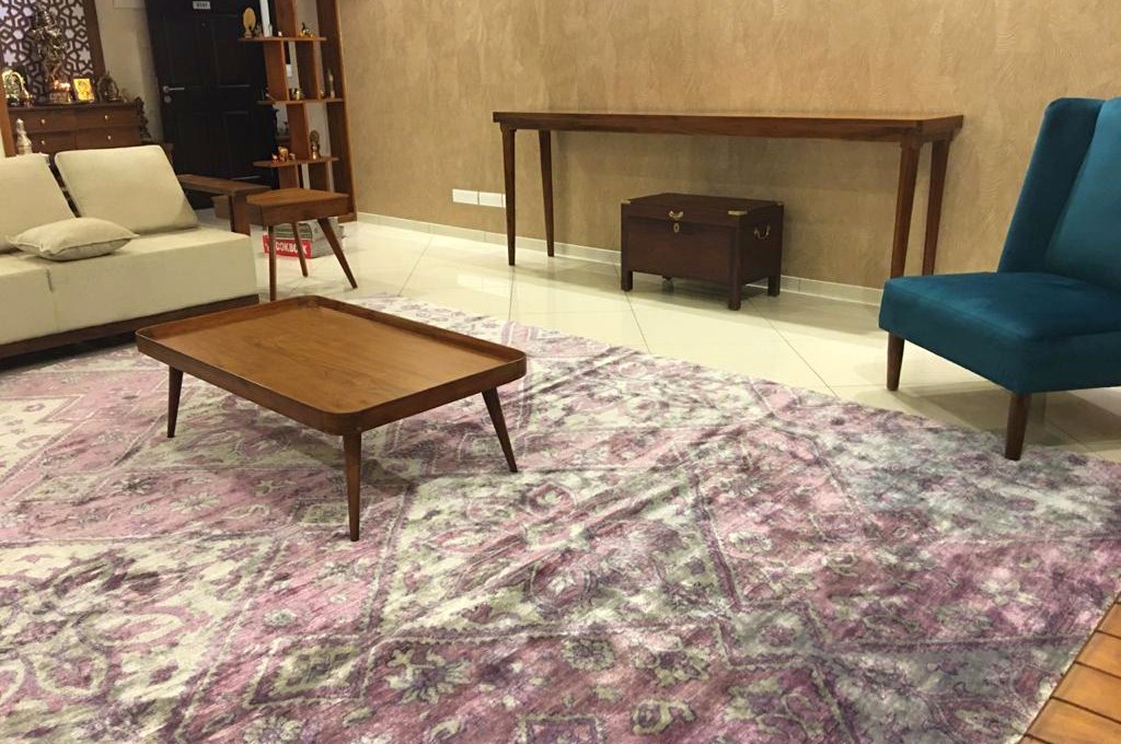 A bamboo silk rug laid in a client&rsquo;s living room, coffee table on top, sofa beside