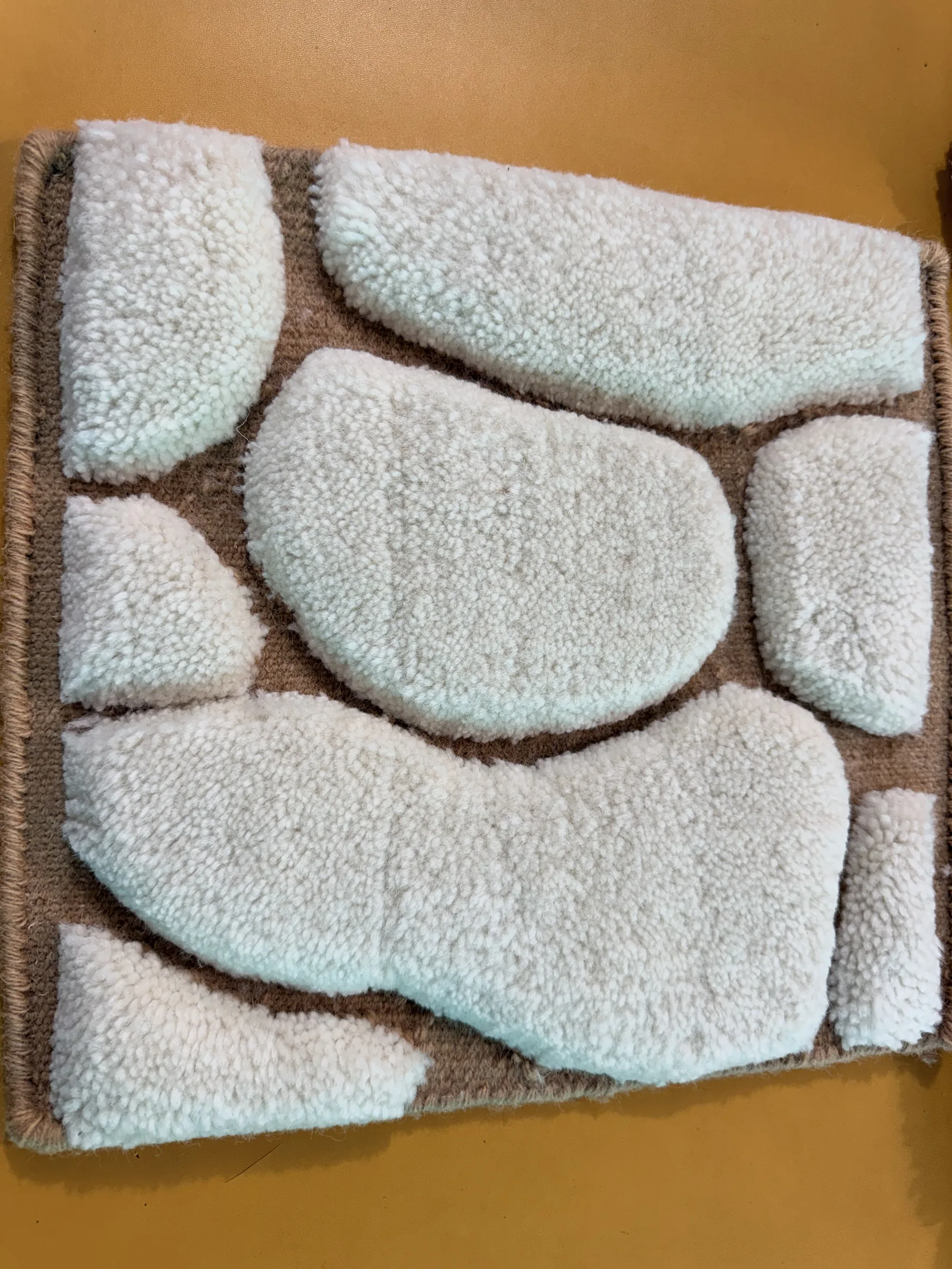 Close crop of a completed hand-carved rug showing the crisp shear line around the motif
