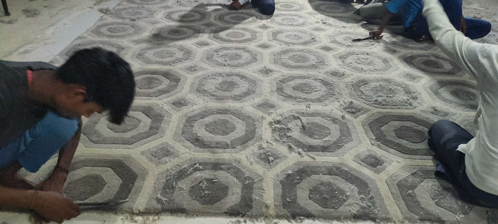 Carved detail being finished on a rug for a hotel programme