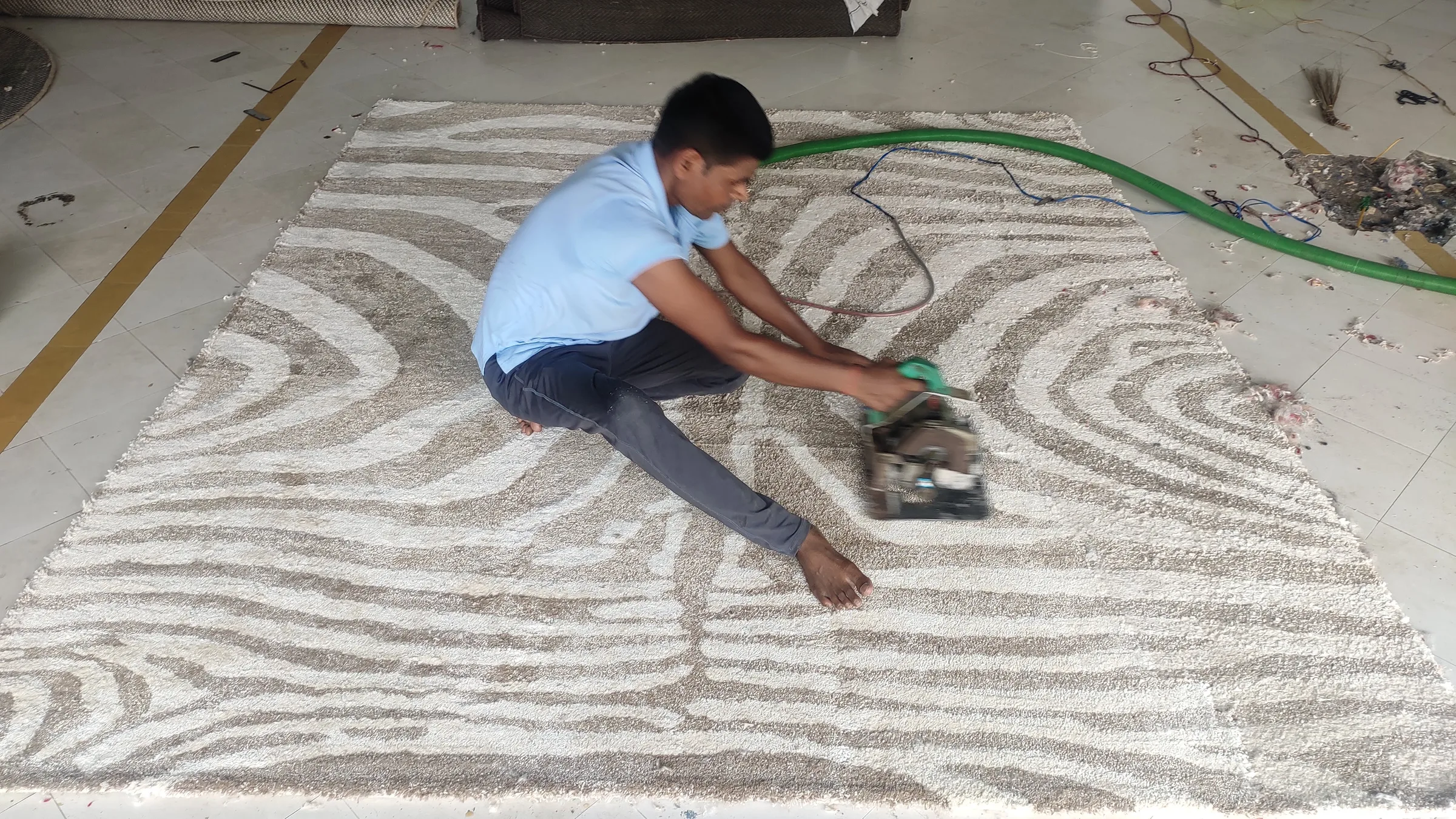 Wide view of a carving bay with several rugs partly carved and loose fibre on the floor