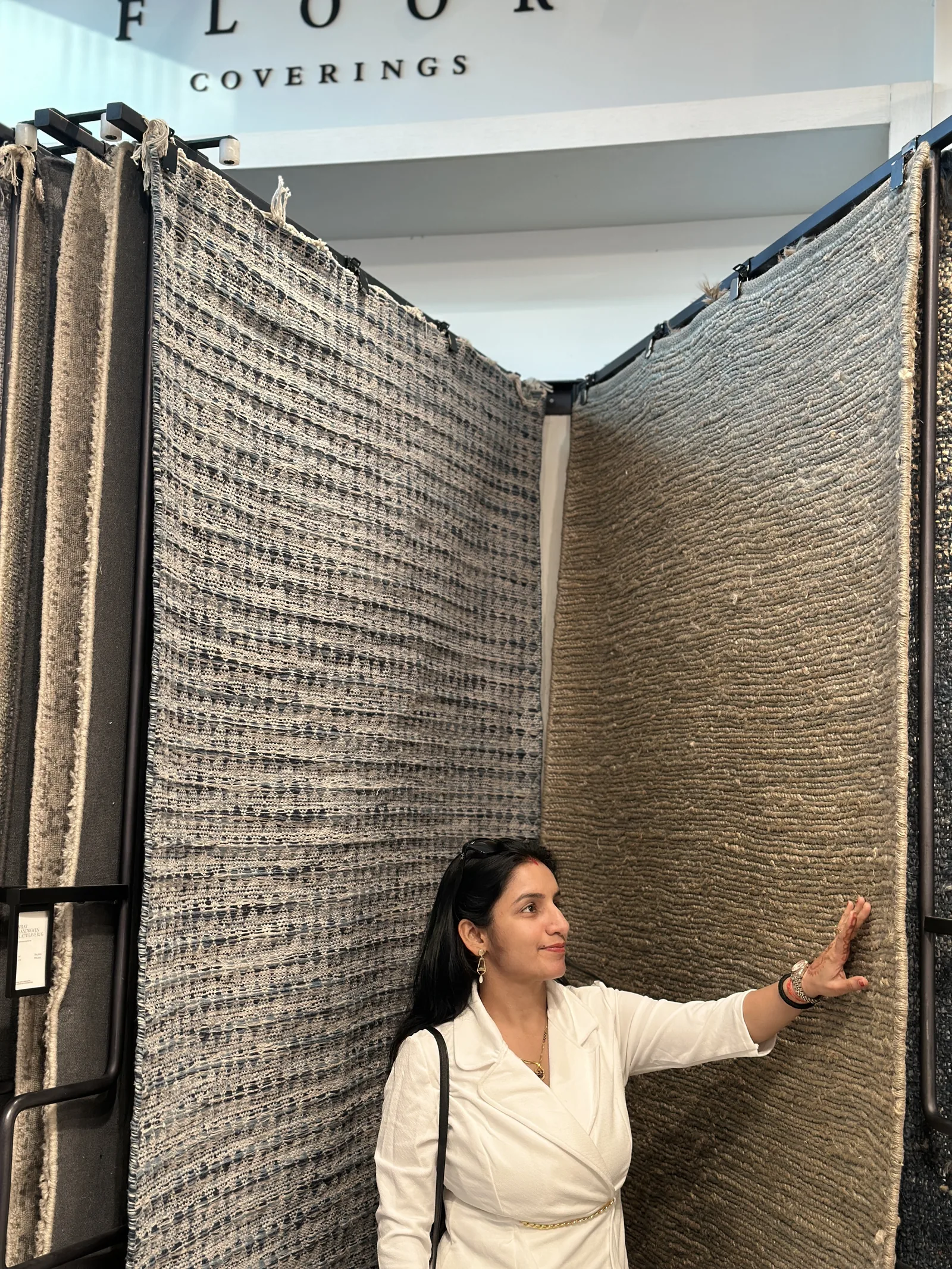 PiHue co-founder Ruchika at a rug showroom, standing beside displayed rugs