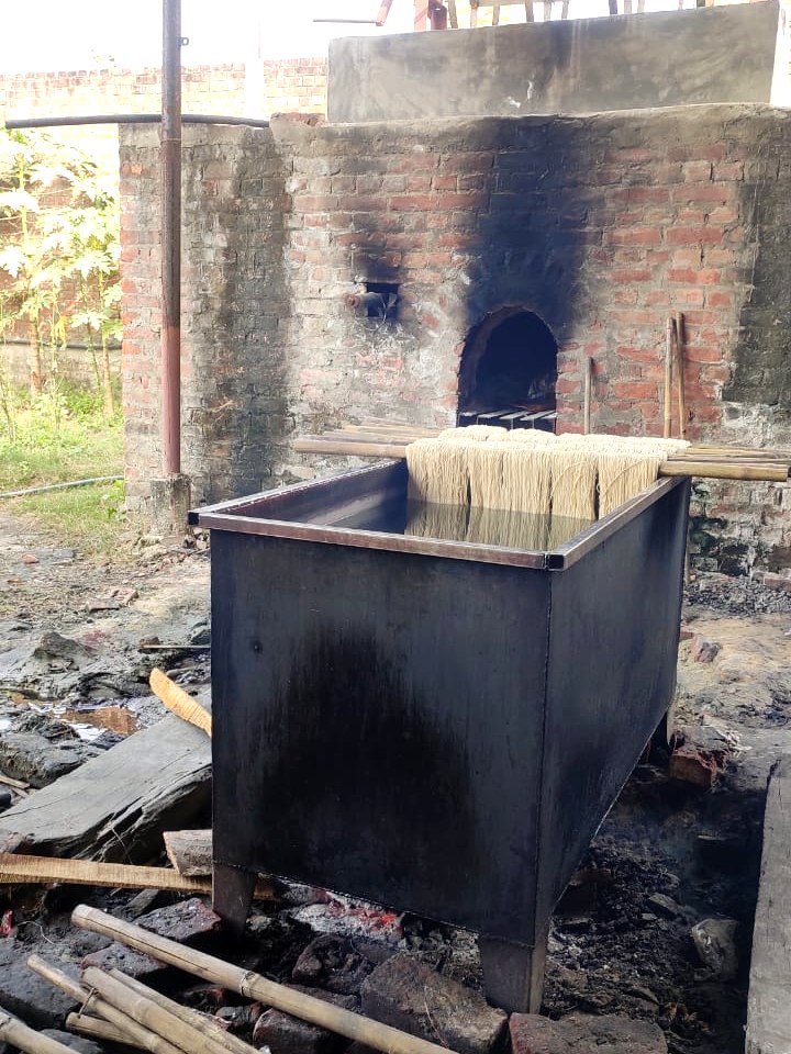 Stage 03 — at the contracted dye plant, yarn being lowered into the vat over the furnace