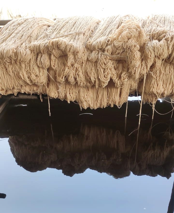 Stage 03 — yarn suspended above the dyeing vat at the contracted plant