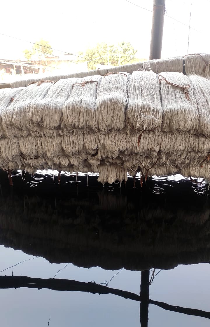 Dyed wool yarn reflected in the water below at the contracted dye plant
