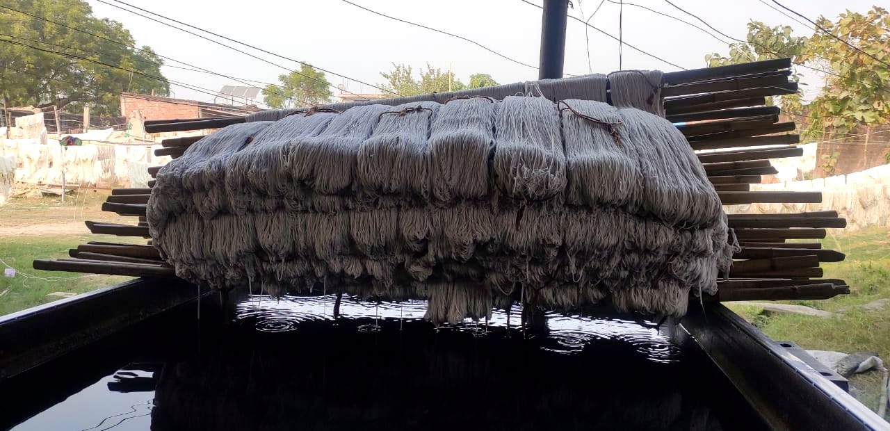 Stage 03 — freshly dyed yarn lifted from the vat, colour taken, still wet