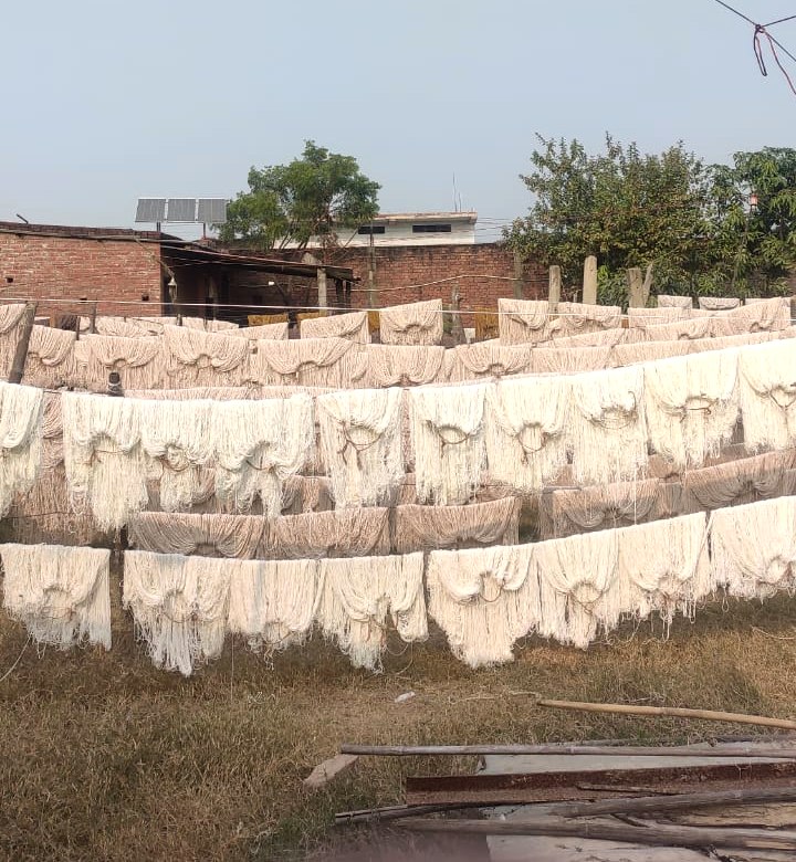 Stage 03 — rows of dyed yarn hung to dry in the open