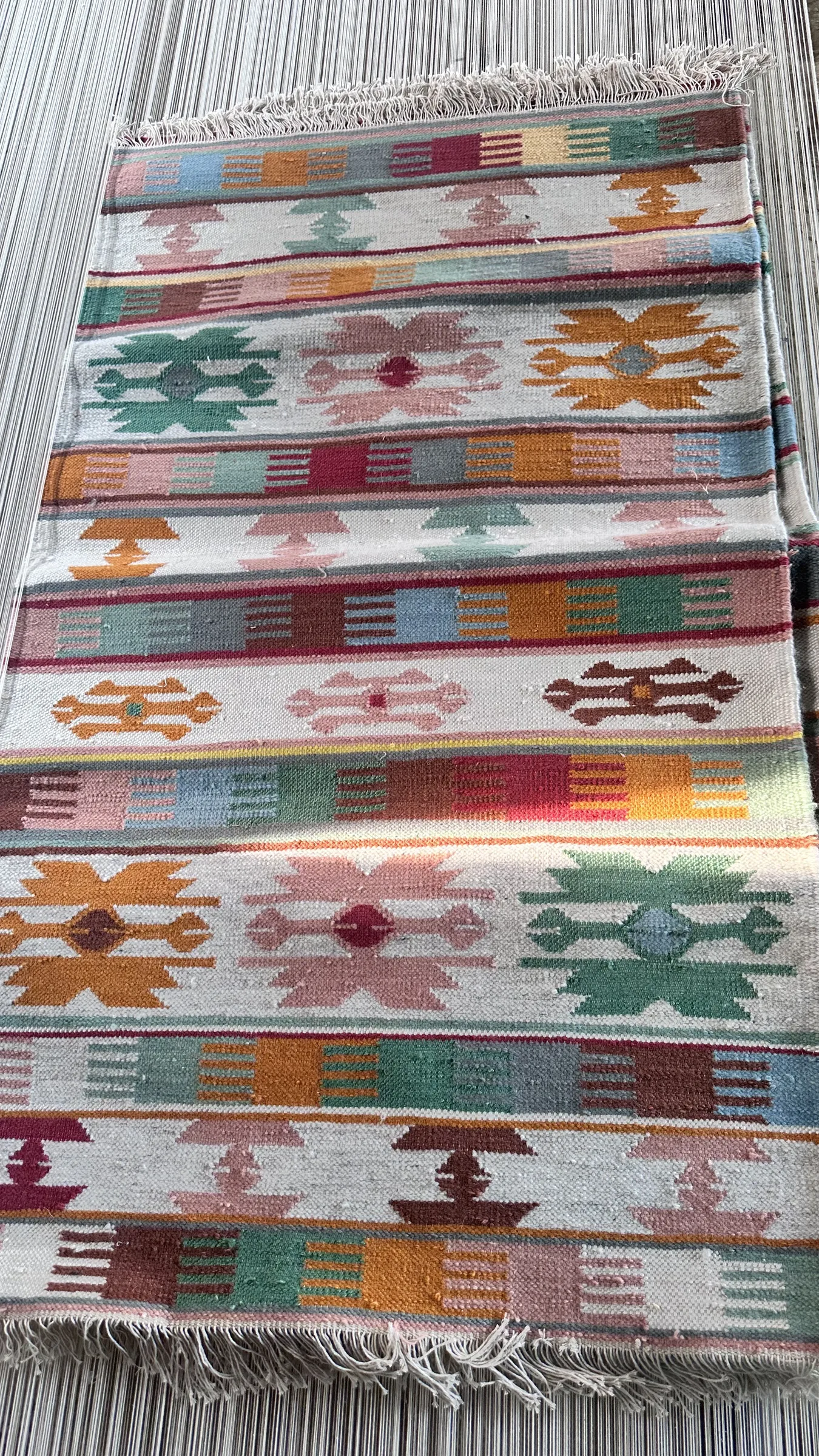 Close view of the shuttle passing across a partly-woven flatweave