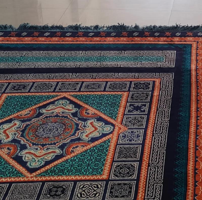 Hand-knotted rug corner showing a central medallion, layered geometric borders and fringed edge