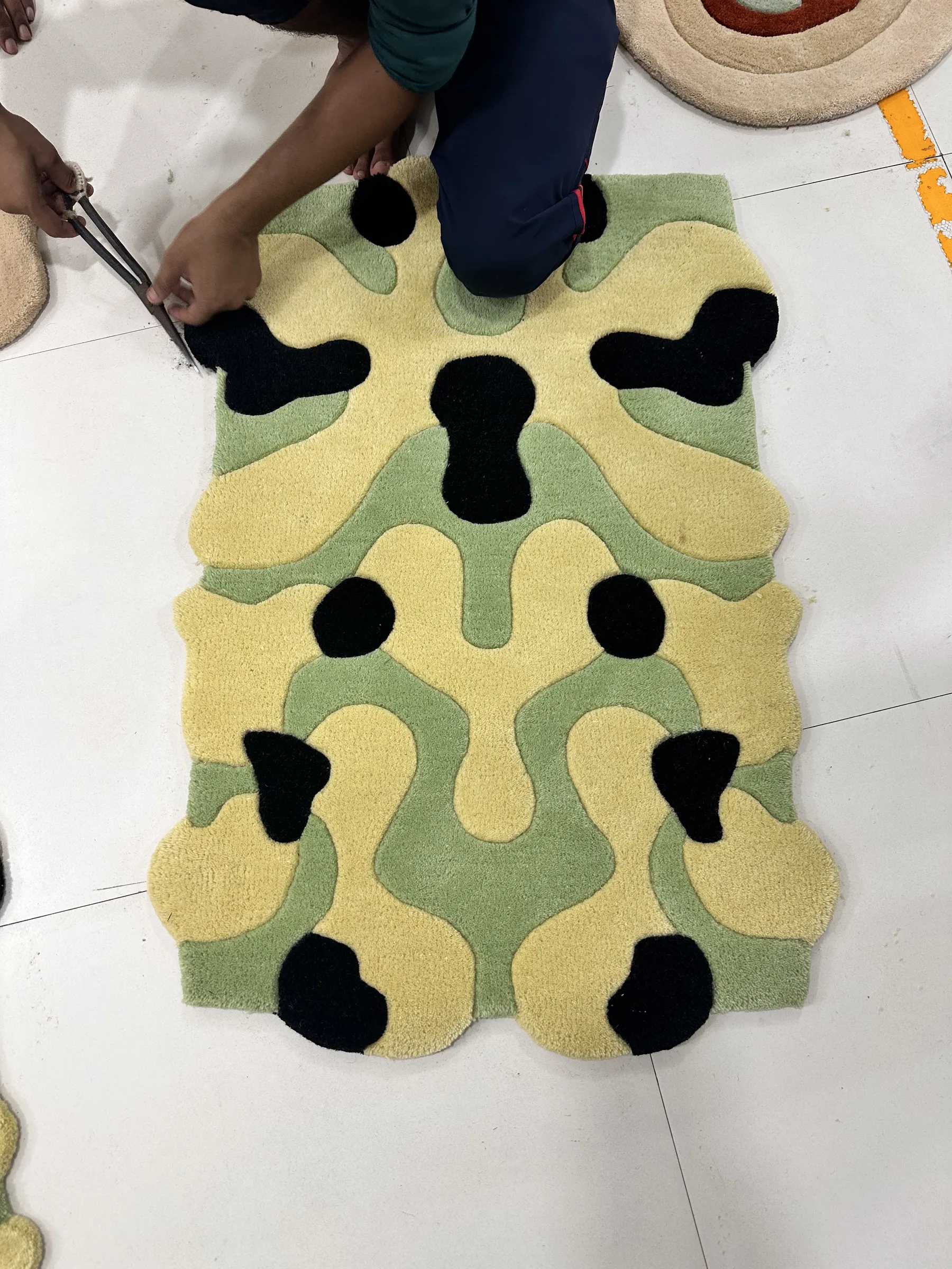 Close crop of the reverse of a tufted rug showing latex sealing the tufts to the primary backing