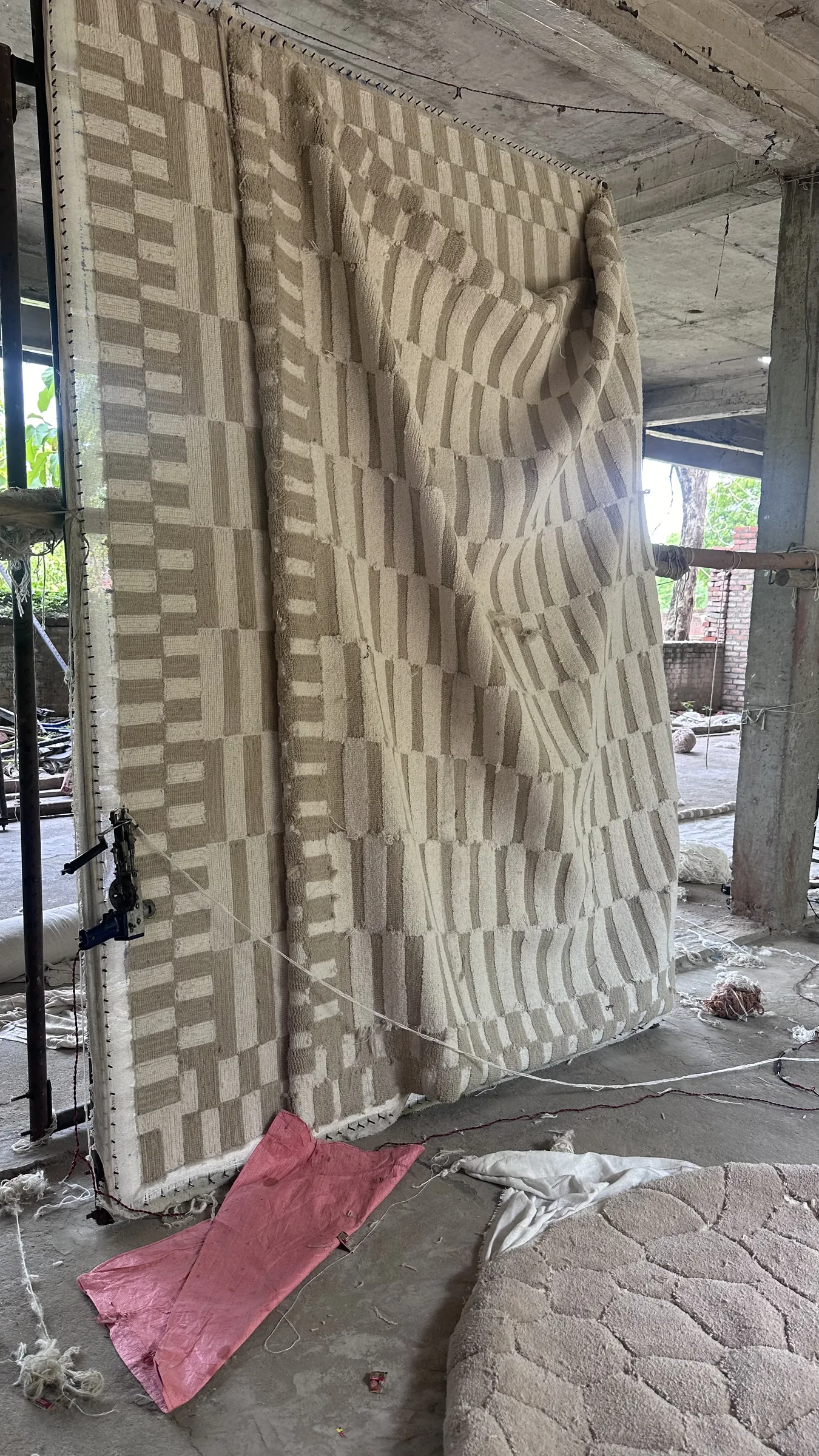 A wide view of the hand-tufted loom bay with rugs in progress on stretched primary canvas