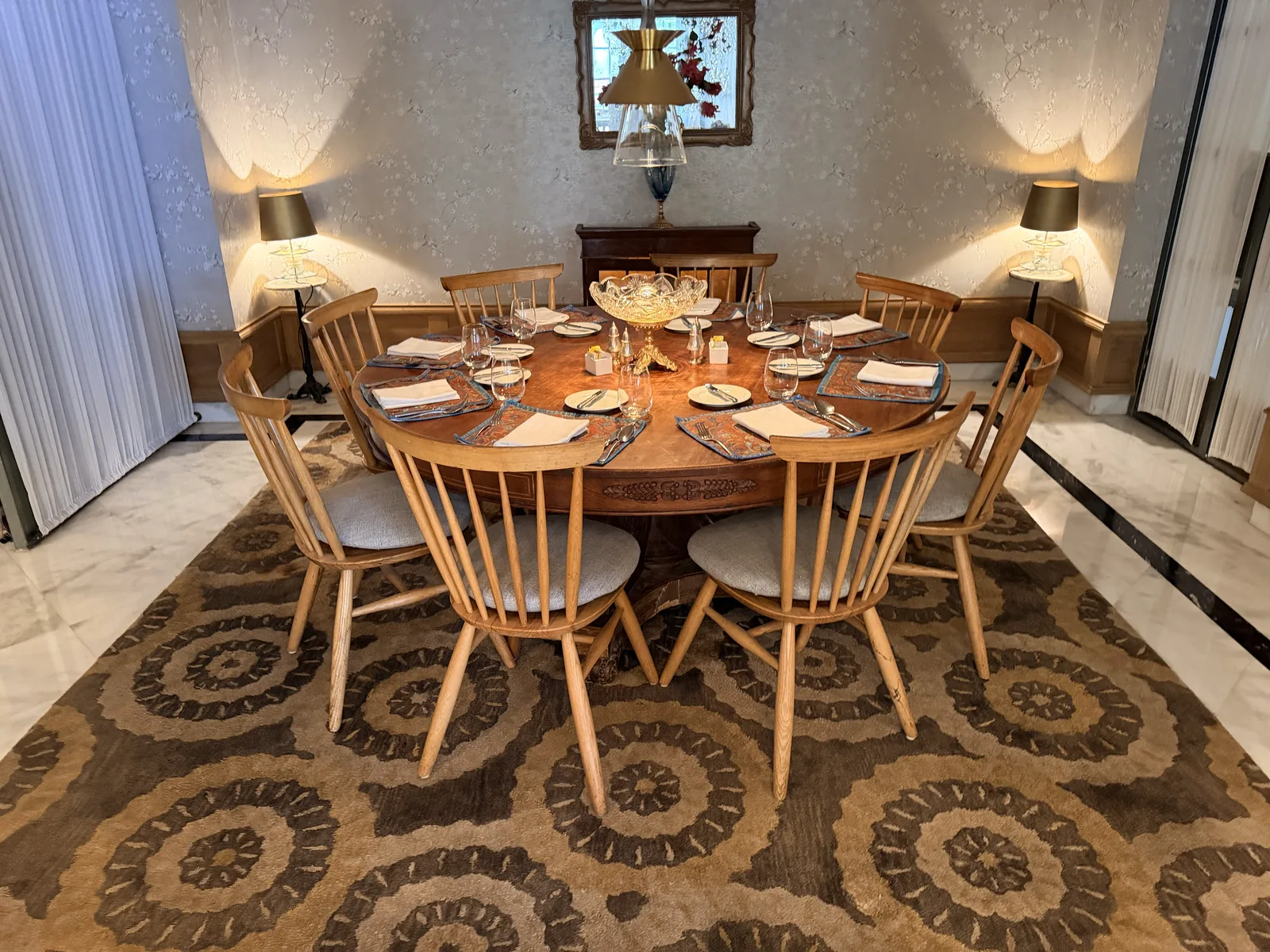 A handmade rug under a dining table, extending well beyond the chair pull-out