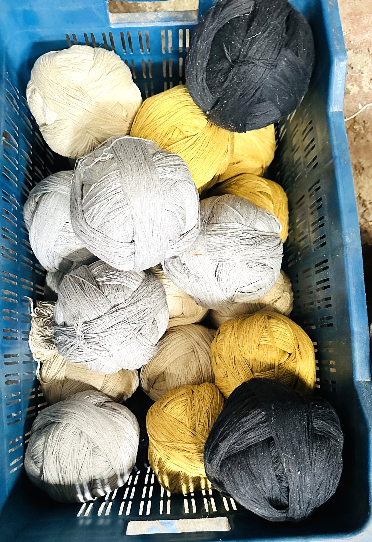 Stage 03 — dyed wool wound into balls, ready for the loom