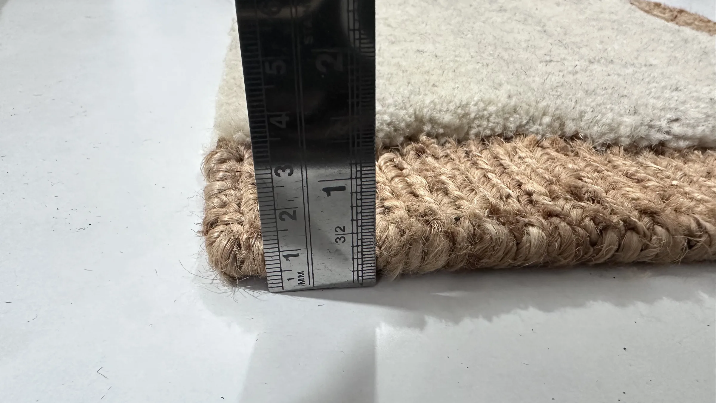 A finisher inspecting knot density on the reverse of a completed hand-knotted rug