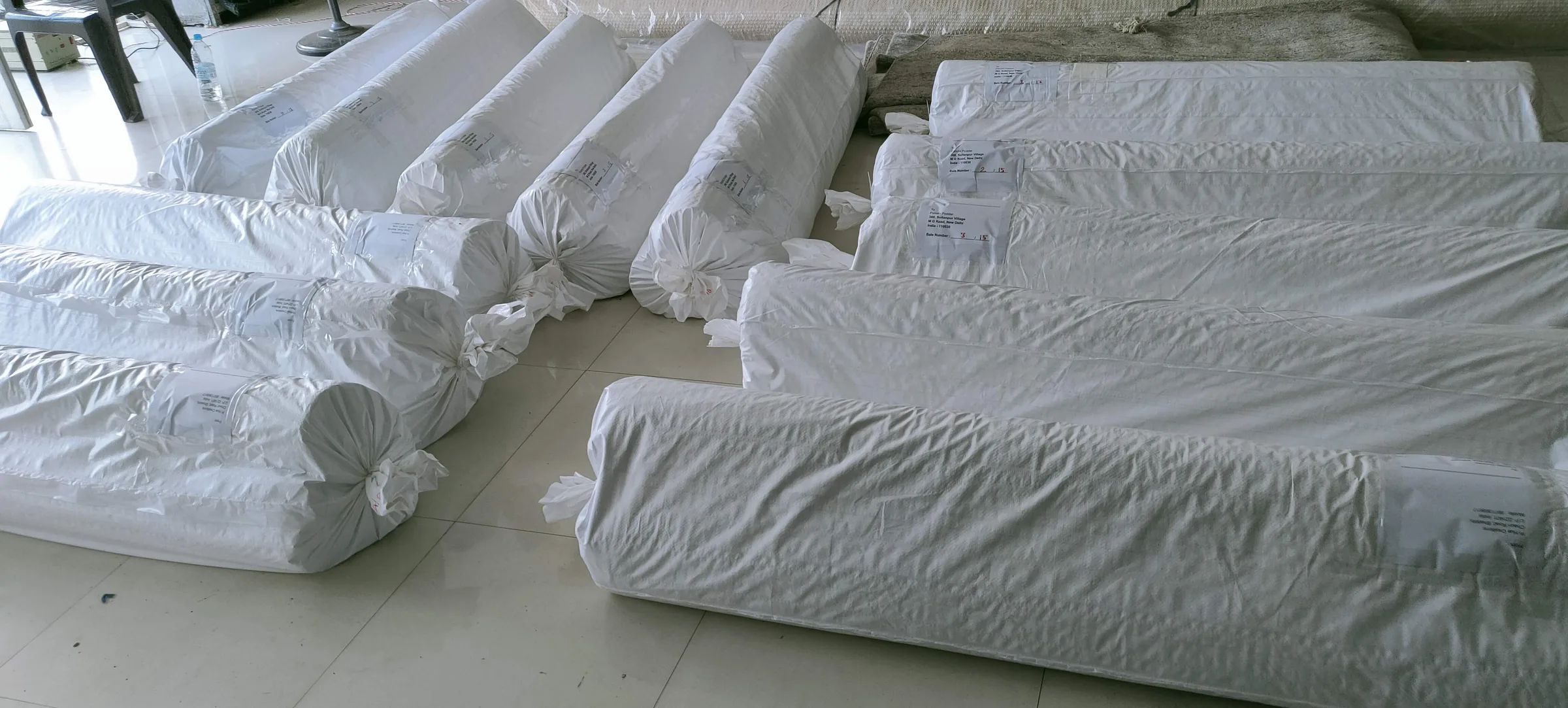 Multiple rolled rugs stacked in the packing bay ready for wrap