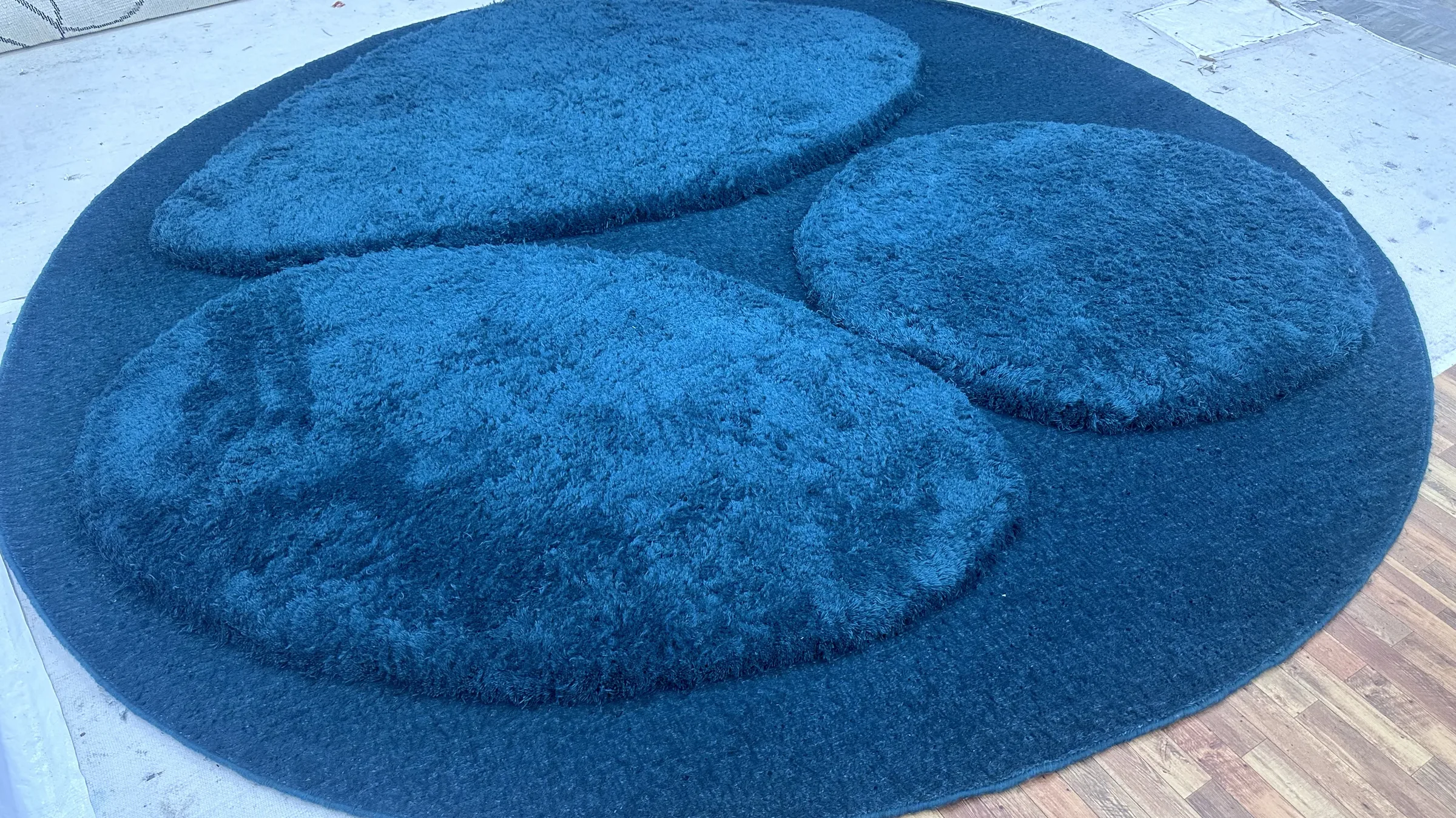 Pile height being measured on an in-process rug with a small ruler pressed into the pile