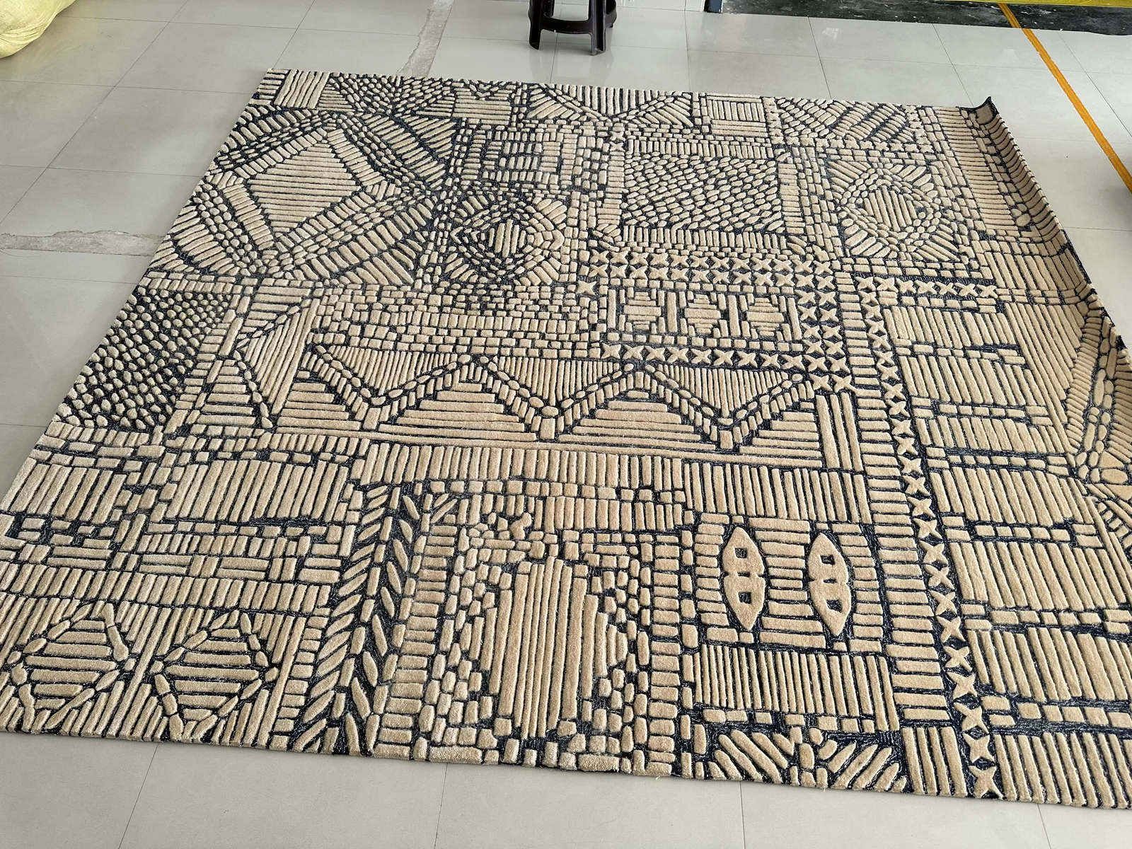 A hand-tufted rug with a bold geometric pattern in cream and grey wool