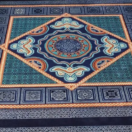 Close-up of a silk hand-knotted medallion — the fine detail and light-catch that silk pile gives