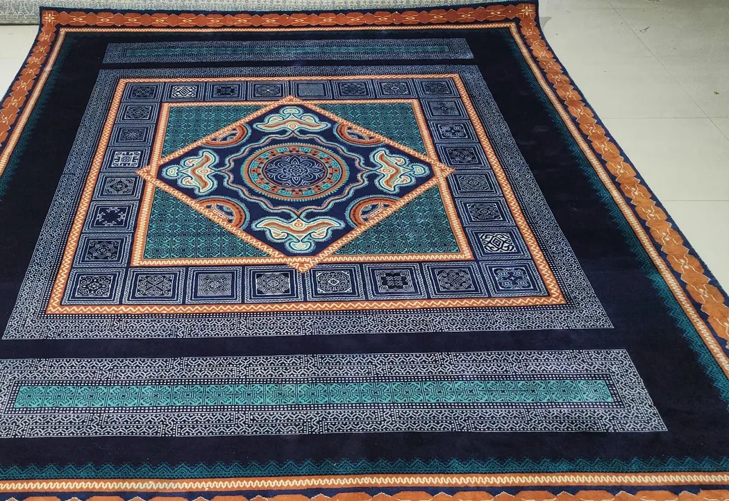 A silk hand-knotted rug with a navy, teal and orange medallion — finished, before dispatch