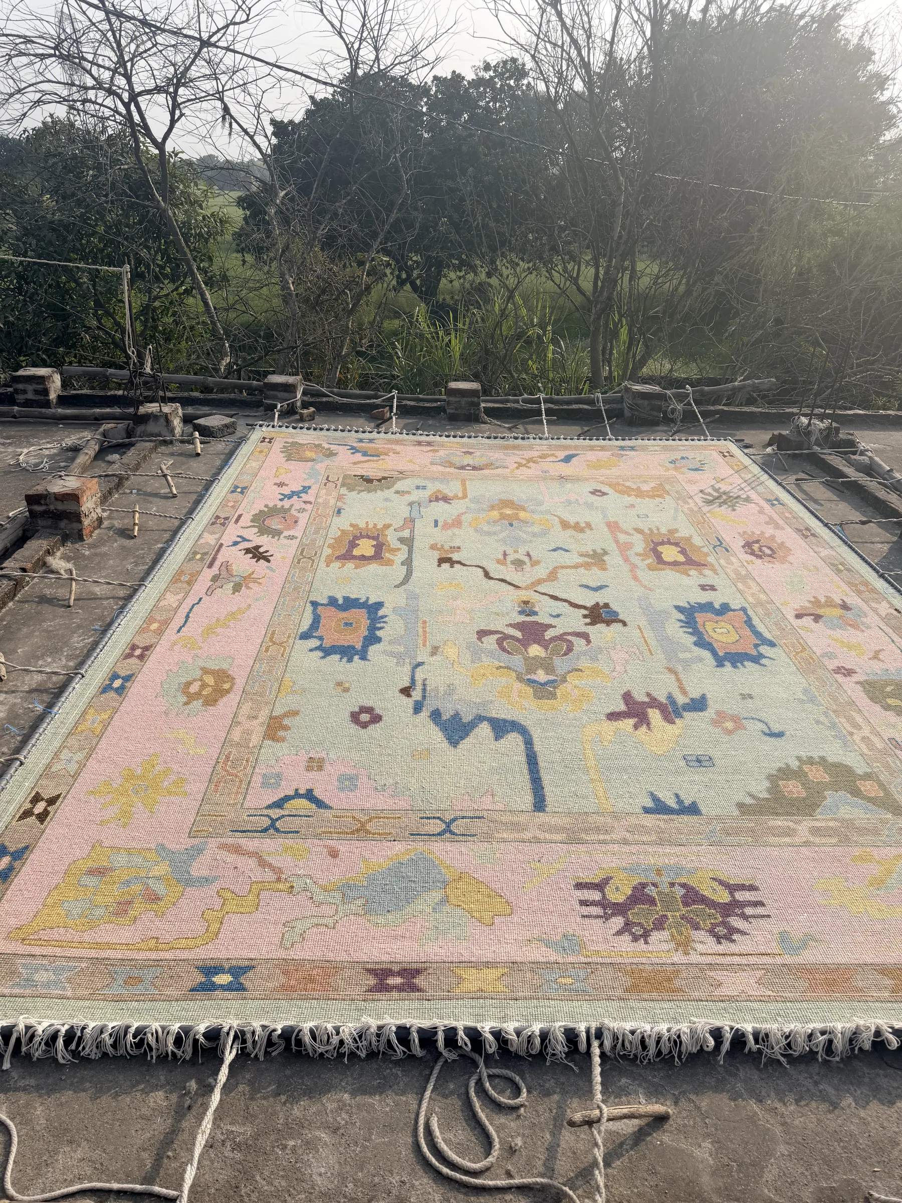 Close view of the pinning stage on a stretching frame, the rug held taut for finishing