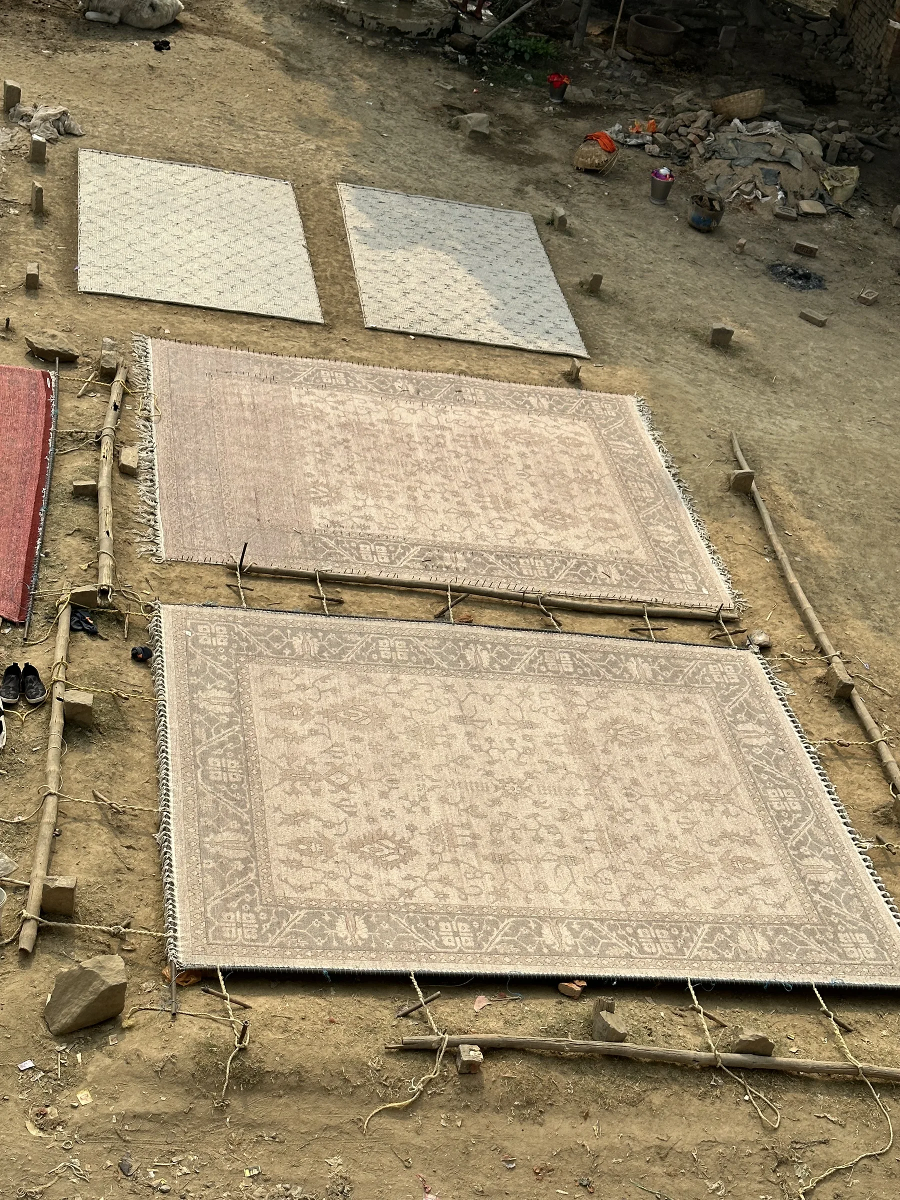 A rug pinned and stretched over a wooden frame to true its shape to the specified dimensions