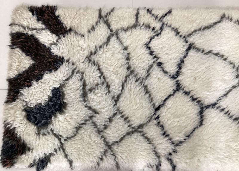 Close detail of a deep ivory shag pile with dark hand-drawn diamond lattice