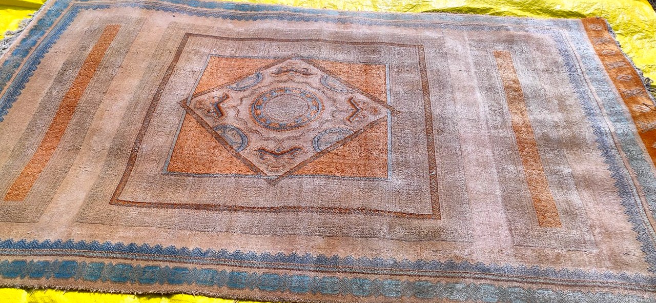 A silk rug after an antique-finish wash, the pile softened and colour taken back deliberately