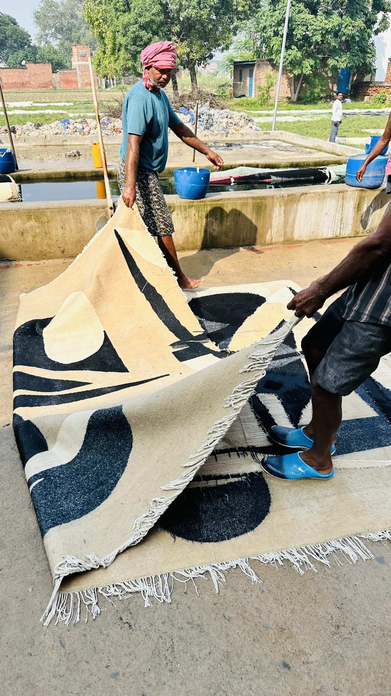 A finished rug's width being measured with a tape at the second axis