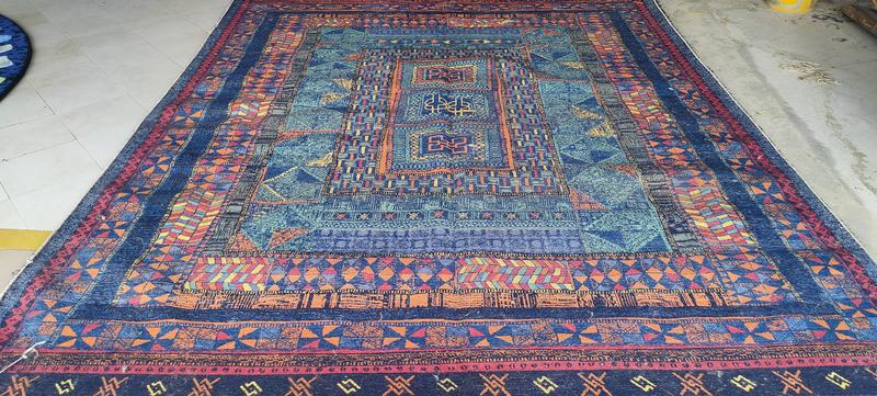 Hand-knotted rug in indigo and orange with concentric geometric medallions and banded borders