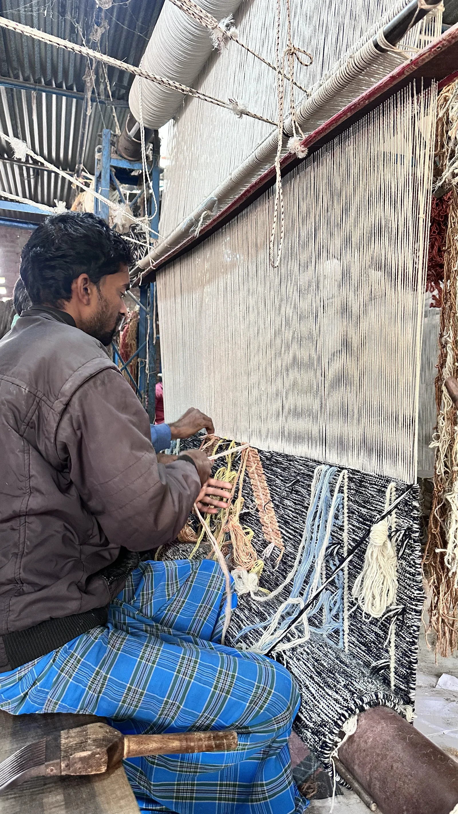 A weaver at work on a flatweave loom at PiHue, Bhadohi